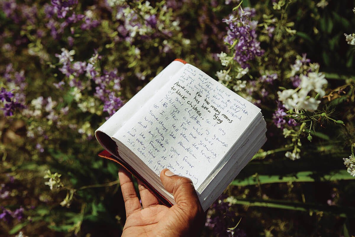 Fidel holds his writing journal at Cylburn Arboretum. His new book, the antiracist, is due out august 11.