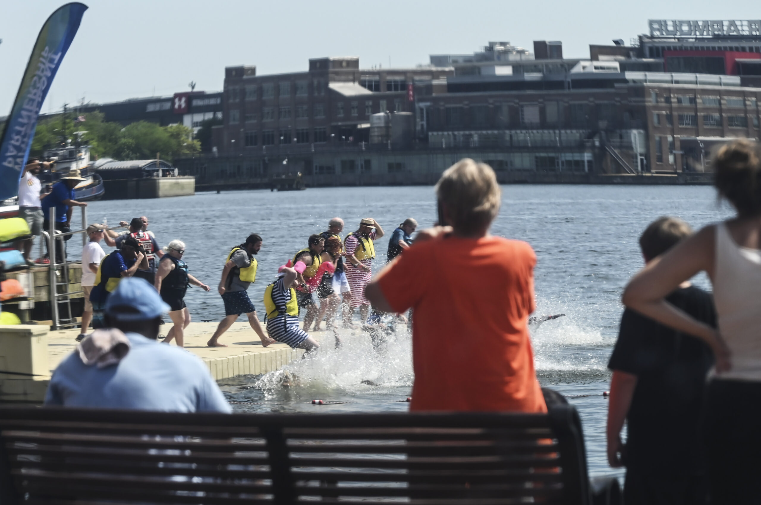 Spectators take in the harbor plunge by land and by sea.
