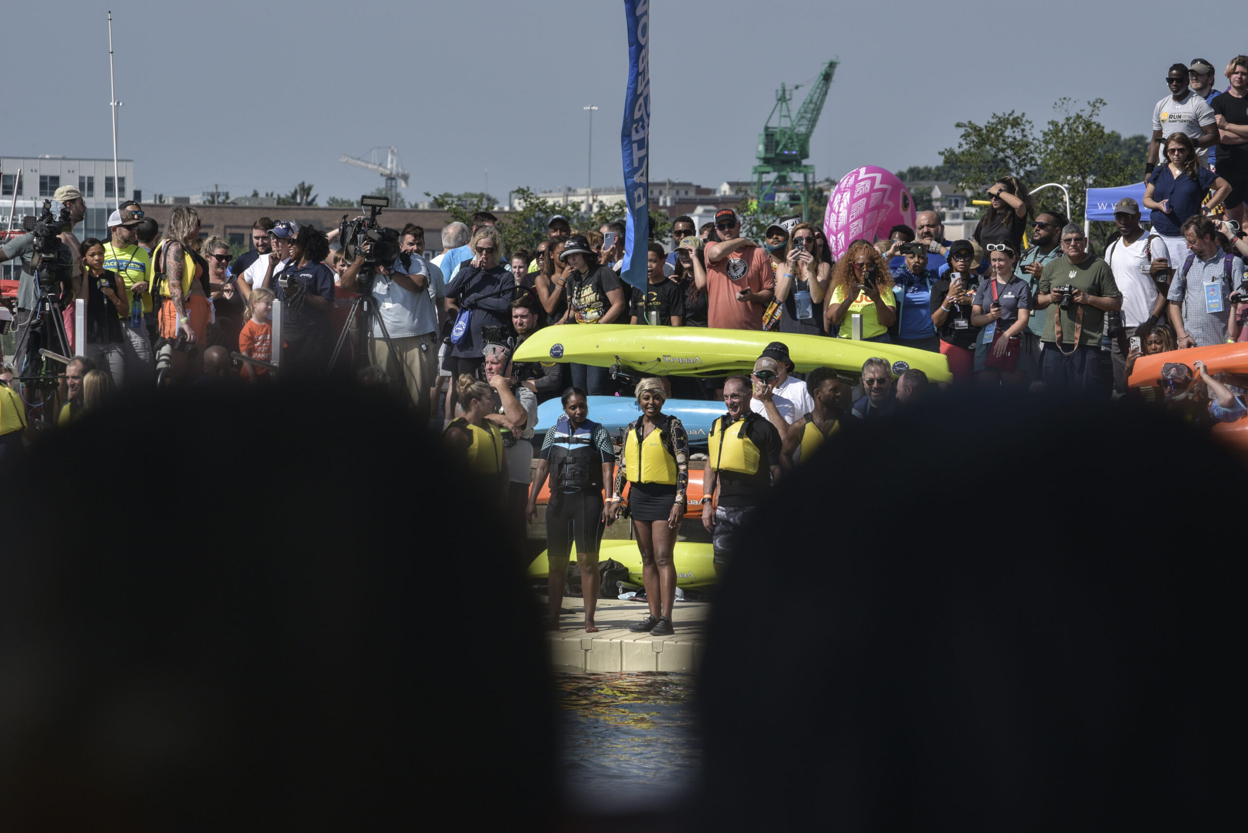 Spectators take in the harbor plunge by land and by sea.